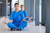 stock photo of pressure  - two young healthcare workers meditation during break to release work pressure - JPG 