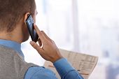 stock photo of newspaper  - Businessman from behind with mobile phone - JPG 