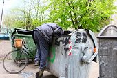 foto of man  - A homeless man looking for food in a garbage dumpster - JPG 