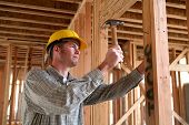 foto of construction  - A handsome construction man using a hammer to nail together wood - JPG 