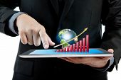 stock photo of earth  - Business man holding the modern digital tablet pc with success growth chart and earth  - JPG 