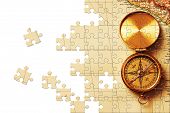 stock photo of longitude  - Puzzle Antique brass compass over old map background - JPG 