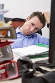 picture of businessmen  - Office businessman at his desk full of documents showing an overwhelmed expression - JPG 