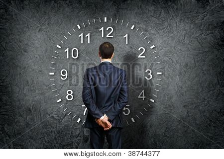Picture or Photo of Businessman standing and making his choice between times