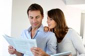 stock photo of newspaper  - Couple reading news on newspaper and internet - JPG 