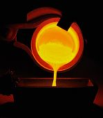 picture of pour  - Molten gold being poured from a crucible into an ingot mold with the light coming from the gold itself - JPG 