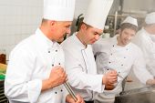 pic of industrial  - Two male cooks working in professional industrial kitchen prepare food - JPG 