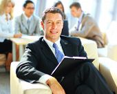 picture of meeting  - Happy business man with colleagues at a conference in the background - JPG 