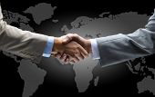 picture of handshake  - Handshake with map of the world in background - JPG 
