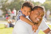 picture of youngster  - Happy African American Father and Mixed Race Son Playing Piggyback in the Park - JPG 