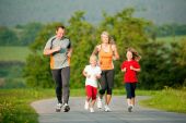 picture of outdoor  - Family jogging outdoors with the kids in a beautiful summer landscape in the late afternoon sun - JPG 