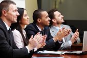 stock photo of group  - Multi ethnic business group greets somebody with clapping and smiling - JPG 