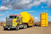 stock photo of transportation  - A yellow transport trailer picking up two newly manufactured and coated 400 BBL - JPG 