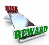 stock photo of balancing  - The words Risk and Reward on a see - JPG 