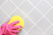 stock photo of tiles  - Hand and glove cleaning the bathroom tiles - JPG 