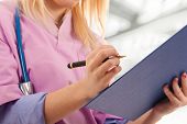 image of medical  - Young nurse writing medical records - JPG 