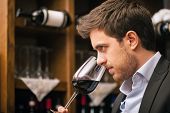 stock photo of man  - Man tasting a glass of red wine - JPG 